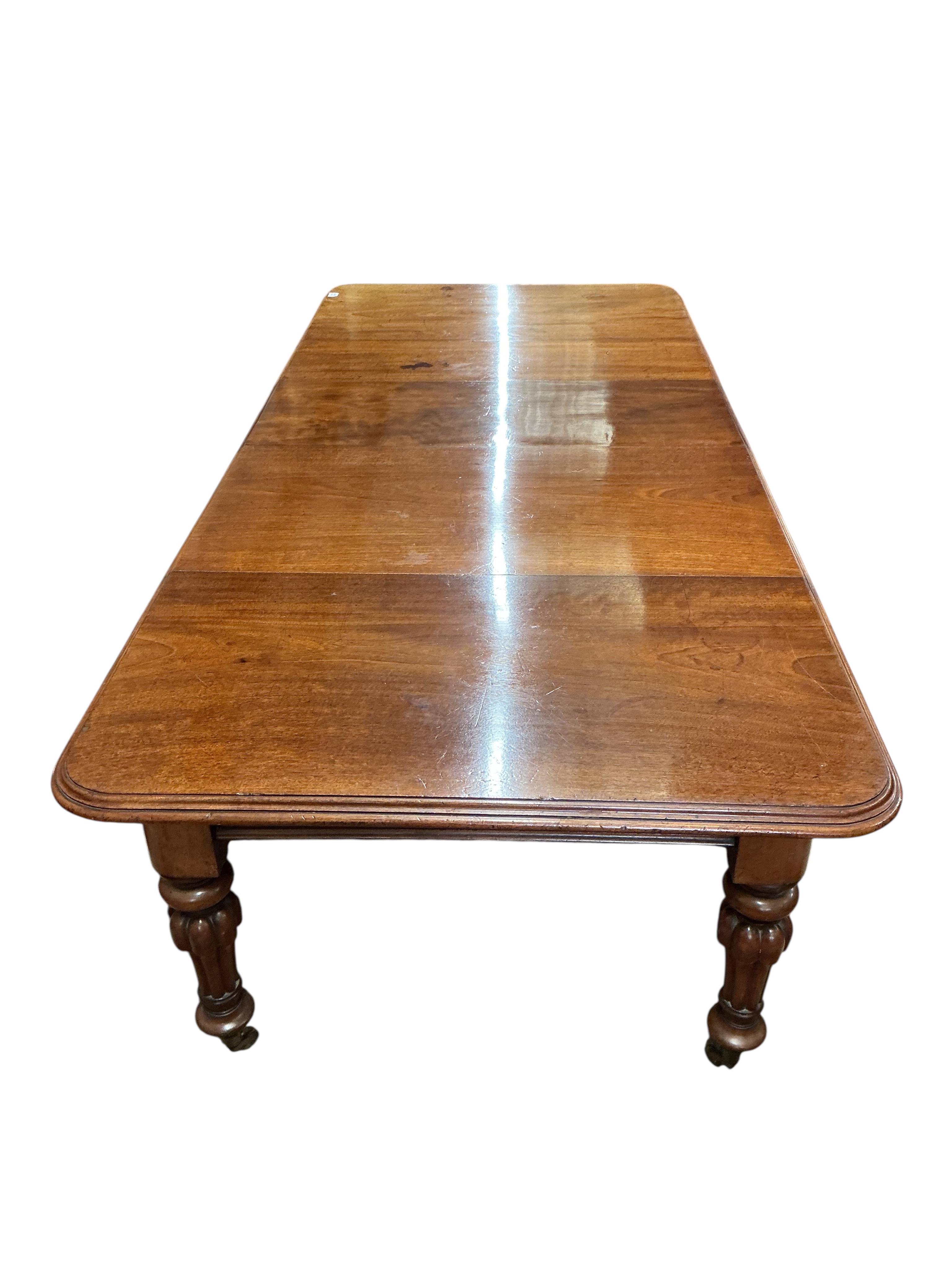 A Victorian mahogany extending dining table, width 285cm extended, three spare leaves
